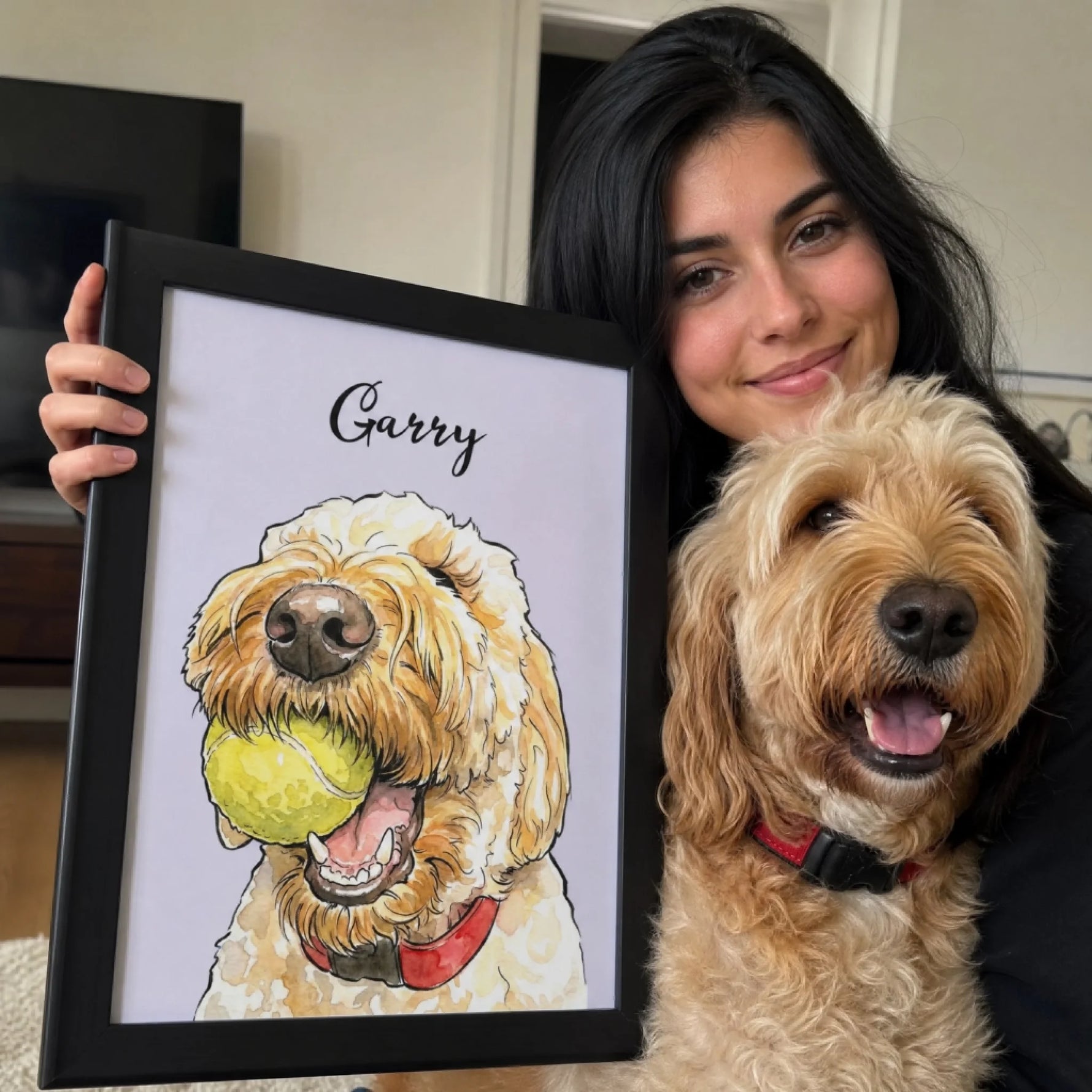 Woman posing with her curly-haired dog and a framed custom watercolor pet portrait personalized with the name Garry.