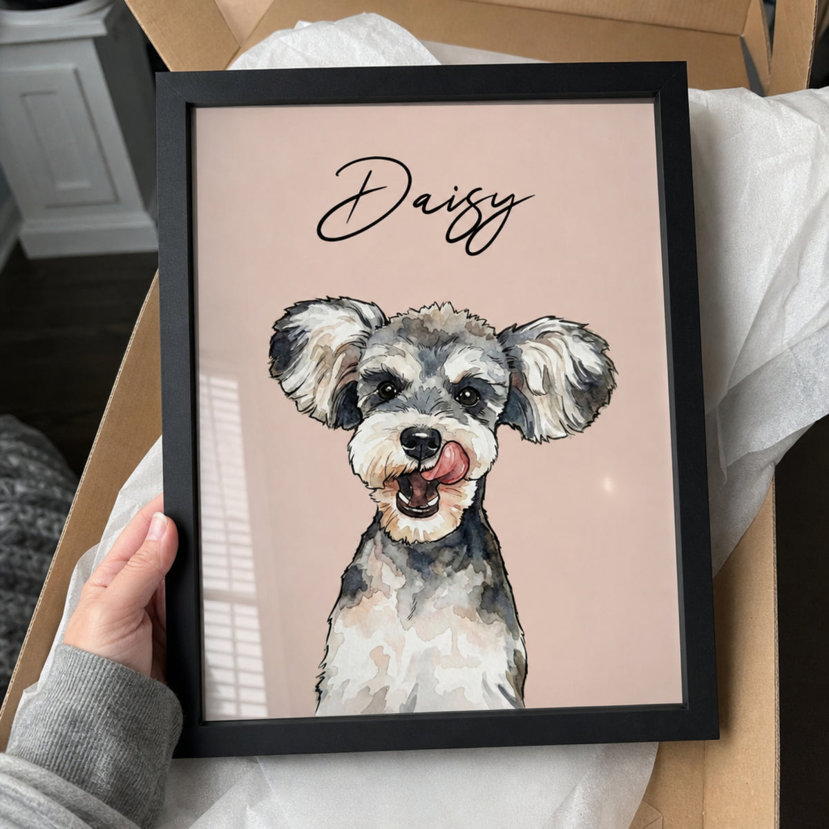 Framed custom watercolor dog portrait personalized with the name Daisy on a soft pink background.
